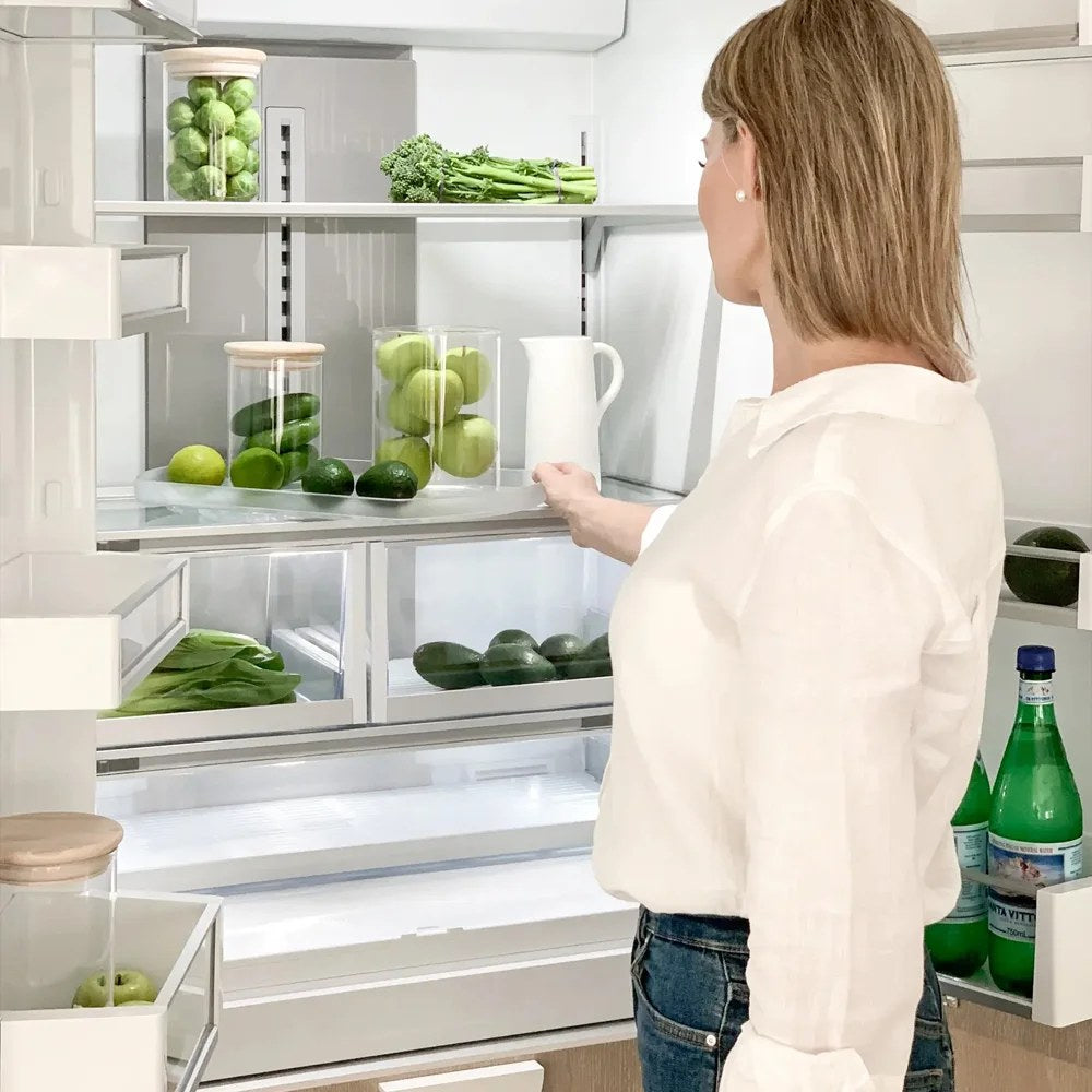 Suport rotativ Comfort Spin montat pe raftul unui frigider deschis, cu produse proaspete organizate