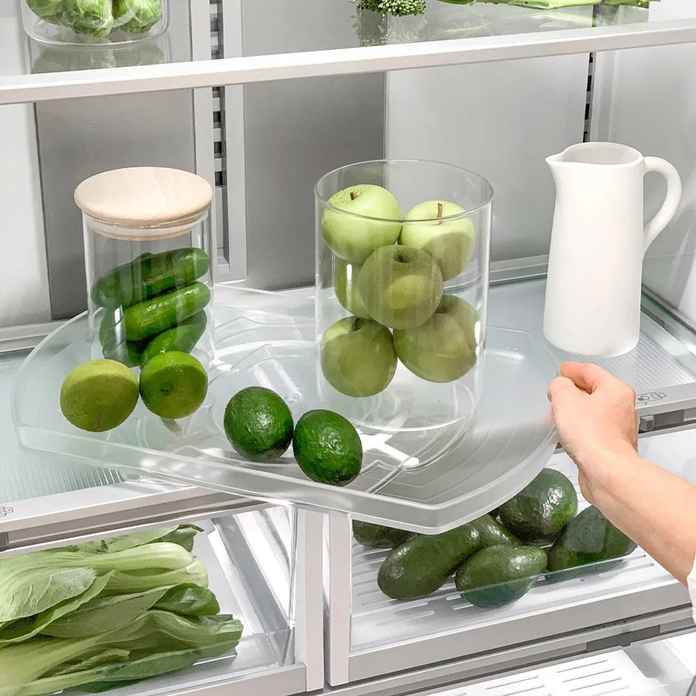 Femeie care alege fructe și legume proaspete de pe suportul rotativ Comfort Spin din frigider